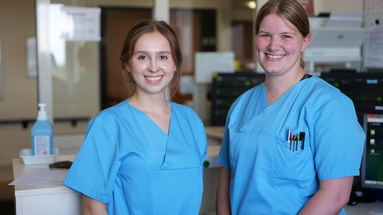  Zwei Pflegerinnen blicken in Kamera im Stationszimmer Kardiologie B6 und B2 des Albertinen Krankenhauses in Hamburg-Schnelsen