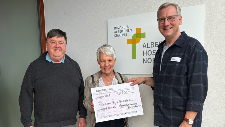 Jürgen Czischke, Susanne Rummel und Jens Klindworth bei der Scheckübergabe im Eingangsbereich des Albertinen Hospiz Norderstedt