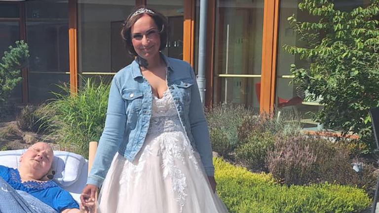 Braut Christina im Hochzeitskleid hält im sonnigen Innenhof des Albertinen Hospiz Norderstedt die Hand ihrer im Bett liegenden Mutter. Braut Christina im Hochzeitskleid hält im sonnigen Innenhof des Albertinen Hospiz Norderstedt die Hand ihrer im Bett liegenden Mutter.