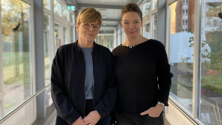 Sabine Kalkhoff (links) und Valeska Stephanow stehen nebeneinander und blicken in die Kamera beim Workshop zum Thema „Spracherwerb in der Pflege“ für Praxisanleitende der Residenz am Wiesenkamp und im Feierabendhaus Volksdorf