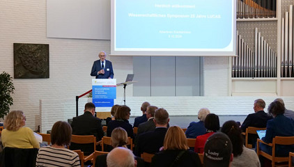Prof. Dr. Wolfgang von Renteln-Kruse steht am Rednerpult und spricht zum Publikum vor einer Projektionsleinwand bei der Jubiläumsveranstaltung mit Symposium und einer Dankesveranstaltung zum 25-jährige Bestehen der LUCAS Langzeit-Kohortenstudie im Hamburger Albertinen Haus und Kirche am Albertinen Krankenhaus. Prof. Dr. Wolfgang von Renteln-Kruse steht am Rednerpult und spricht zum Publikum vor einer Projektionsleinwand bei der Jubiläumsveranstaltung mit Symposium und einer Dankesveranstaltung zum 25-jährige Bestehen der LUCAS Langzeit-Kohortenstudie im Hamburger Albertinen Haus und Kirche am Albertinen Krankenhaus.