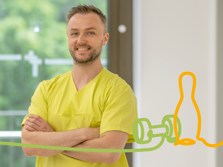 Physiotherapeut steht mit verschränkten Armen in einem Therapiebereich und lächelt in die Kamera. Das Bild steht für professionelle Physiotherapie und Rehabilitation. Physiotherapeut steht mit verschränkten Armen in einem Therapiebereich und lächelt in die Kamera. Das Bild steht für professionelle Physiotherapie und Rehabilitation.