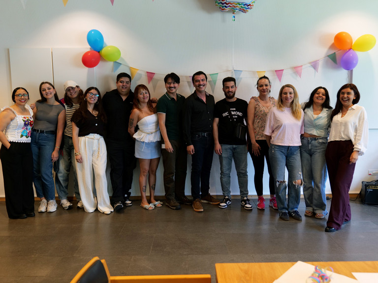 Eine Gruppe internationaler Pflegefachkräfte steht für ein Gruppenfoto zusammen in einem mit Luftballons bunt geschmückten Veranstaltungsraum bei der Anerkennungsfeier für internationale Pflegefachkräfte im Albertinen Krankenhaus in Hamburg.