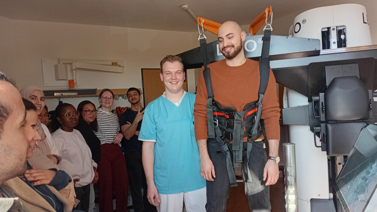Auszubildende des BPA 02-25 der Beruflichen Pflegeausbildung testen im Albertinen Krankenhaus gemeinsam mit Physiotherapeut Tim Göldner den Gangtrainer Lexo im Rahmen des Unterrichts zu digitalen und technischen Unterstützungssystemen in der neurologischen Frührehabilitation.