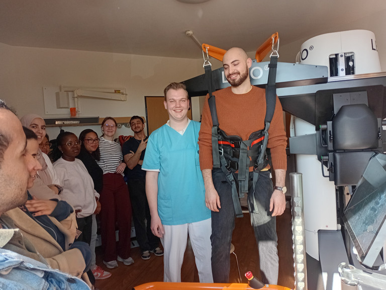 Auszubildende des BPA 02-25 der Beruflichen Pflegeausbildung testen im Albertinen Krankenhaus gemeinsam mit Physiotherapeut Tim Göldner den Gangtrainer Lexo im Rahmen des Unterrichts zu digitalen und technischen Unterstützungssystemen in der neurologischen Frührehabilitation.