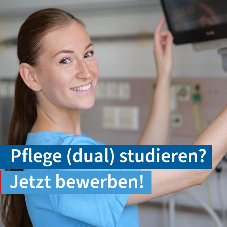 Eine Pflegekraft fasst an einen Monitor in einem Patientenzimmer und blickt in die Kamera