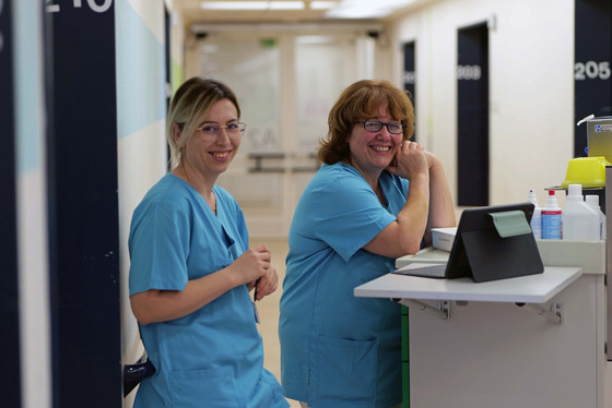 Zwei Pflegerinnen lächeln in die Kamera auf dem Stationsgang der Station AltersTraumaZentrum und Unfallchirurgie im Albertinen Krankenhaus in Hamburg-Schnelsen