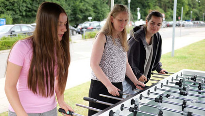 Drei Frauen stehen an einem Tischkicker während eines Spiels beim Sommerfest 2026 auf dem Gesundheitscampus Volksdorf des Evangelischen Amalie Sieveking Krankenhauses, der Residenz am Wiesenkamp, des Feierabendhauses Volksdorf und der Albertinen Kindertagesstätte Volksdorf. 