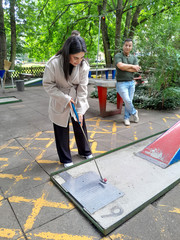 Eine Auszubildende setzt beim Minigolf den Golfschläger an den Ball beim Azubi-Tag 2025 von Werkstück Raumgestaltung und Versorgungstechnik in Berlin