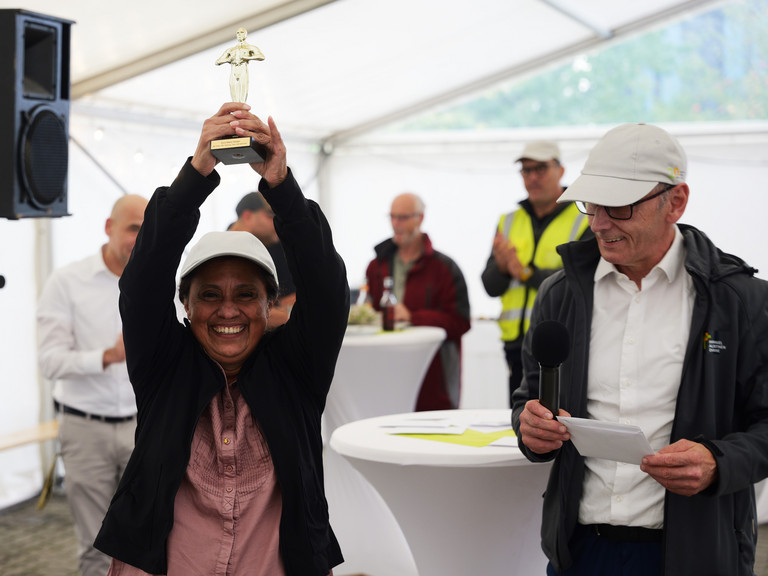 Eine Mitarbeiterin hält neben Geschäftsführer Ralf Zastrau eine Metallfigur in die Luft und blickt lachend in die Kamera bei der Jubiläumsfeier 20 Jahre Albertinen Services Hamburg ASH in Rellingen. Eine Mitarbeiterin hält neben Geschäftsführer Ralf Zastrau eine Metallfigur in die Luft und blickt lachend in die Kamera bei der Jubiläumsfeier 20 Jahre Albertinen Services Hamburg ASH in Rellingen.