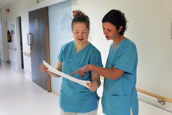 Zwei Hebammen besprechen gemeinsam Unterlagen – enge Zusammenarbeit im geburtshilflichen Team.
