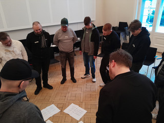 Rund zehn Personen stehen im Kreis und diskutieren über auf dem Boden liegende Ausdrucke mit Text beim Teamtag vom Meisterbetrieb für Handwerk Werkstück Berlin zum Thema "Gute Kommunikation verbindet" in Berlin-Wannsee Rund zehn Personen stehen im Kreis und diskutieren über auf dem Boden liegende Ausdrucke mit Text beim Teamtag vom Meisterbetrieb für Handwerk Werkstück Berlin zum Thema "Gute Kommunikation verbindet" in Berlin-Wannsee