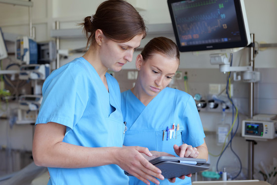 Zwei Pflegerinnen der Stroke Unit stehen mit Tablet in einem Patientenzimmer der Klinik für Neurologie und Neurologische Frührehabilitation im Albertinen Krankenhaus in Hamburg-Schnelsen