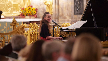 Eine Pianistin sitzt am Konzertflügel und blickt zum Publikum im Kirchensaal beim 10. Herzbrücke-Benefizkonzert im Hamburger „Michel“ der Albertinen-Stiftung. Eine Pianistin sitzt am Konzertflügel und blickt zum Publikum im Kirchensaal beim 10. Herzbrücke-Benefizkonzert im Hamburger „Michel“ der Albertinen-Stiftung.