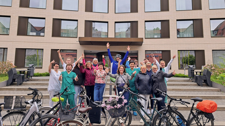 Das Team „Immanuel Klinikum & Netzwerk Gesunde Kinder radeln“ jubelt vor dem Krankenhaus zum 1. Platz beim Stadtradeln Bernau 2025 mit ihren Fahrrädern