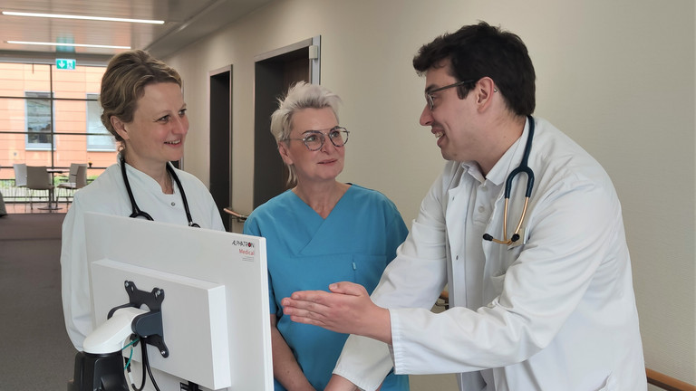 Pflegerin, Ärztin und Arzt reden vor einem Monitor - Immanuel Klinik Rüdersdorf - Karriere