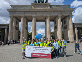 Mitarbeitende mit Banner vor Brandenburger Tor Mitarbeitende mit Banner vor Brandenburger Tor