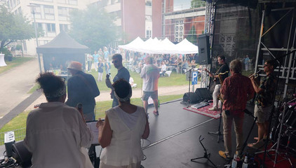 Blick von der professionellen Musikbühne mit Musikern auf die Rasenfläche mit Publikum und Pavillons beim Sommerfest 2026 auf dem Gesundheitscampus Volksdorf des Evangelischen Amalie Sieveking Krankenhauses, der Residenz am Wiesenkamp, des Feierabendhauses Volksdorf und der Albertinen Kindertagesstätte Volksdorf.