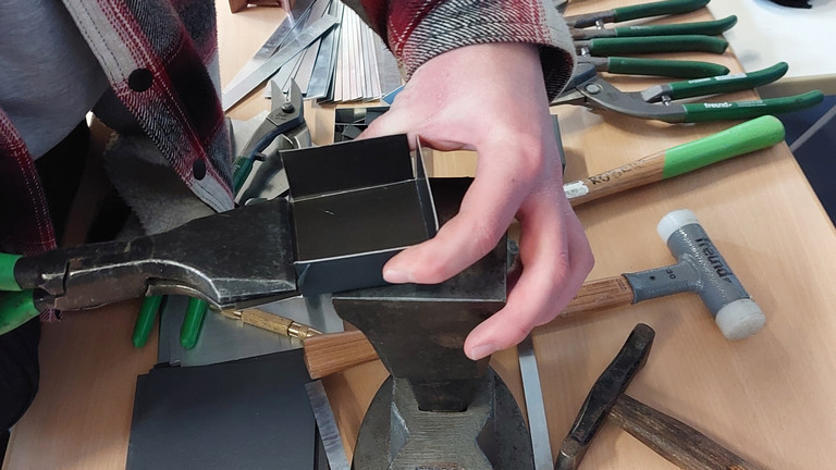 Besucher am Messestand von Werkstück stellt Metallschachtel her