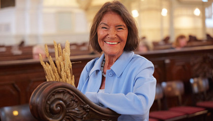 Eine Frau lächelt neben den Kirchenbänken fröhlich in die Kamera beim 10. Herzbrücke-Benefizkonzert im Hamburger „Michel“ der Albertinen-Stiftung. Eine Frau lächelt neben den Kirchenbänken fröhlich in die Kamera beim 10. Herzbrücke-Benefizkonzert im Hamburger „Michel“ der Albertinen-Stiftung.