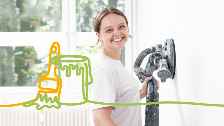 Mitarbeiterin im Malerhandwerk schleift Innenwand mit Gerät und lächelt – Stellenanzeige Maler, Ausbau und Renovierung Mitarbeiterin im Malerhandwerk schleift Innenwand mit Gerät und lächelt – Stellenanzeige Maler, Ausbau und Renovierung