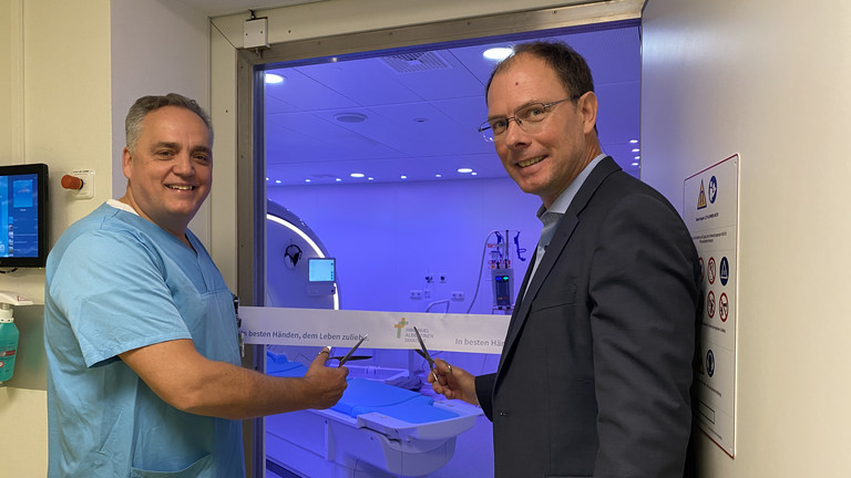 Chefarzt Prof. Christoph Weber und Geschäftsführer Andreas Schneider schneiden das Band vor dem dunkelblau illuminierten Raum mit dem neuen MRT-System im Immanuel Albertinen Zentrum für Radiologie am Standort Ev. Amalie Sieveking Krankenhaus in Hamburg durch Chefarzt Prof. Christoph Weber und Geschäftsführer Andreas Schneider schneiden das Band vor dem dunkelblau illuminierten Raum mit dem neuen MRT-System im Immanuel Albertinen Zentrum für Radiologie am Standort Ev. Amalie Sieveking Krankenhaus in Hamburg durch