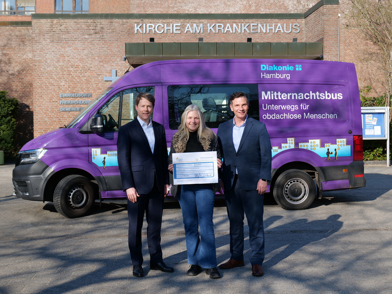 Dr. Thorsten Minuth und Andreas Mende überreichen den Spendenscheck an Sonja Norgall, Verantwortliche für den Mitternachtsbus des Diakonie-Zentrums für Wohnungslose.