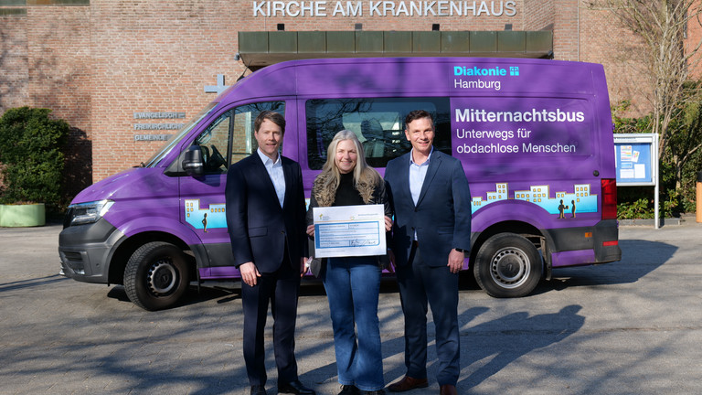 Dr. Thorsten Minuth und Andreas Mende überreichen den Spendenscheck an Sonja Norgall, Verantwortliche für den Mitternachtsbus des Diakonie-Zentrums für Wohnungslose.