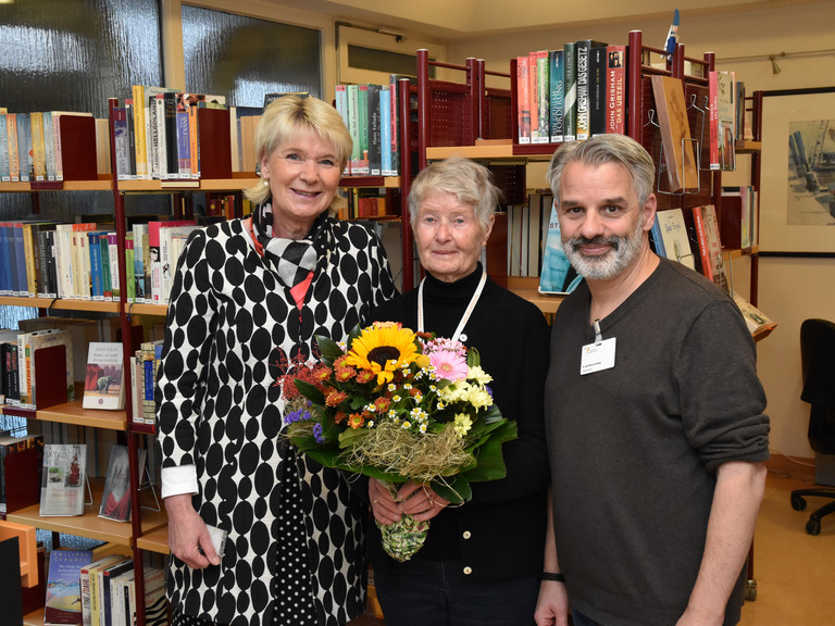 Alberto Correia und Tanja Gronninger überraschten die Jubilarin mit einem Blumenstrauß an ihrem Arbeitsplatz in der Patientenbibliothek