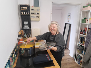 Marion Geisler verfeinert am Herd dei Kürbissuppe im Topf - Immanuel Stadtteilzentrum Borsigwalde