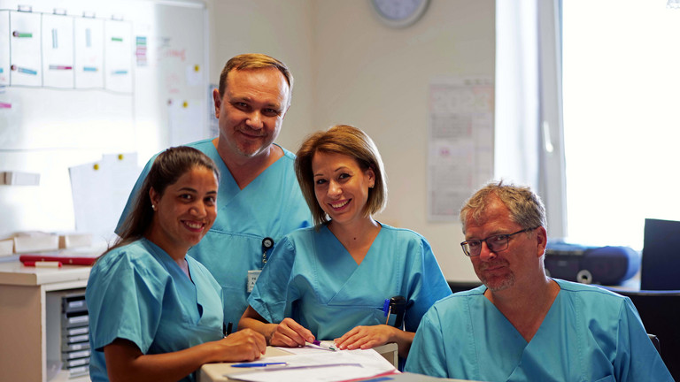 Pflegeteam im Stationszimmer der Chirurgie blickt in Kamera im Albertinen Krankenhaus in Hamburg-Schnelsen