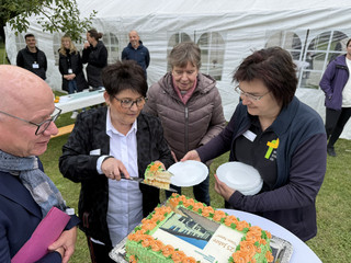 Mehrere Personen stehen um einen Tisch mit Herbert Blum und schneiden den Jubiläumskuchen an beim Fest zum 25-jährigen Jubiläum des Immanuel Suchthilfeverbunds Guben mit besonderen Wohnformen für abhängigkeitskranke Menschen in Thüringen Mehrere Personen stehen um einen Tisch mit Herbert Blum und schneiden den Jubiläumskuchen an beim Fest zum 25-jährigen Jubiläum des Immanuel Suchthilfeverbunds Guben mit besonderen Wohnformen für abhängigkeitskranke Menschen in Thüringen