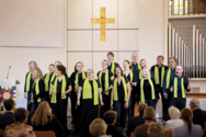 Die Mitglieder des Albertinen-Mitarbeitenden-Gospelchors singen bei einem Gospelkonzert auf der Bühne der Kiche beim Albertinen Krankenhaus in festlicher schwarzer Kleidung mit grünen Schals. Die Mitglieder des Albertinen-Mitarbeitenden-Gospelchors singen bei einem Gospelkonzert auf der Bühne der Kiche beim Albertinen Krankenhaus in festlicher schwarzer Kleidung mit grünen Schals.
