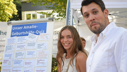 Ein Mann und eine Frau stehen beim Quiz der Geburtshilfe des Amalie Sieveking Krankenhauses an den Ständen des Gesundheitscampus Volksdorf der Immanuel Albertinen Diakonie beim Stadtteilfest Volksdorf in Hamburg