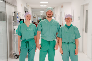 Drei operationstechnische Assistenten in grünen Kasacks auf dem Flur des Operationstraktes im Albertinen Krankenhaus Hamburg Schnelsen