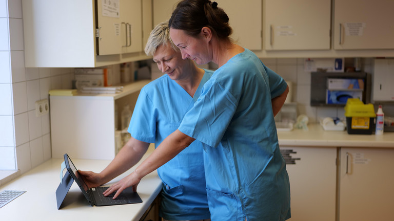 Zwei Pflegerinnen blicken im Stationszimmer der Neurologie auf ein Tablet im Albertinen Krankenhaus in Hamburg-Schnelsen