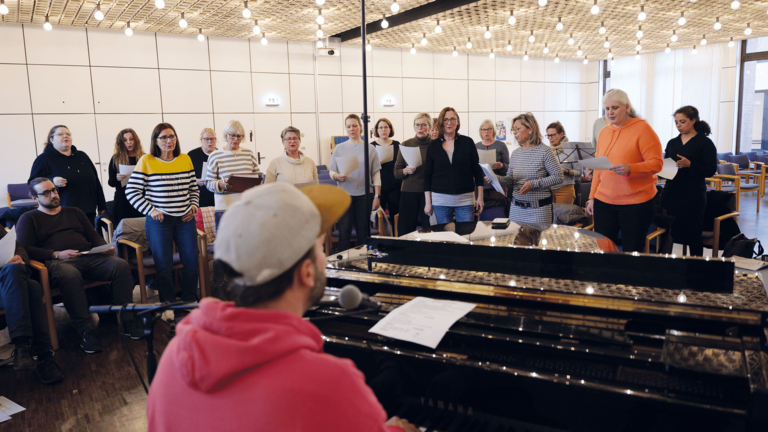 Der Albertinen Gospelchor bei einer Chorprobe mit Klavier und Chorleiter in Hamburg-Schnelsen