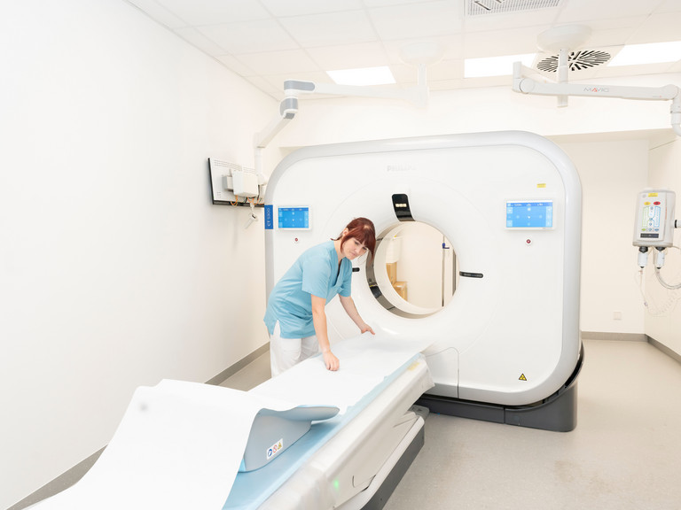 Eine Medizinische Technologin (MTR) in Funktionskleidung bereitet vor einem großen Röntgensystem in einem Untersuchungsraum der Immanuel Klinik Rüdersdorf die Untersuchungsliege vor. Eine Medizinische Technologin (MTR) in Funktionskleidung bereitet vor einem großen Röntgensystem in einem Untersuchungsraum der Immanuel Klinik Rüdersdorf die Untersuchungsliege vor.