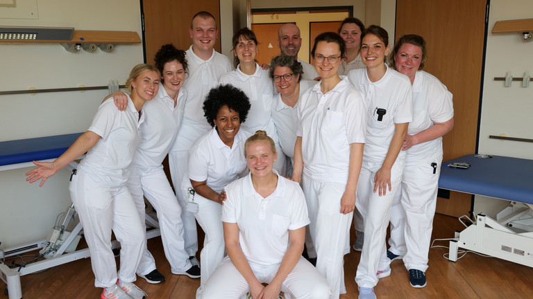 Eine Gruppe neurologischer Therapiefachkräfte steht in weißer Funktionskleidung im Halbkreis und greift nach Luftballons in einem Therapieraum im Interdisziplinären Therapiezentrum im Albertinen Krankenhaus Hamburg Eine Gruppe neurologischer Therapiefachkräfte steht in weißer Funktionskleidung im Halbkreis und greift nach Luftballons in einem Therapieraum im Interdisziplinären Therapiezentrum im Albertinen Krankenhaus Hamburg