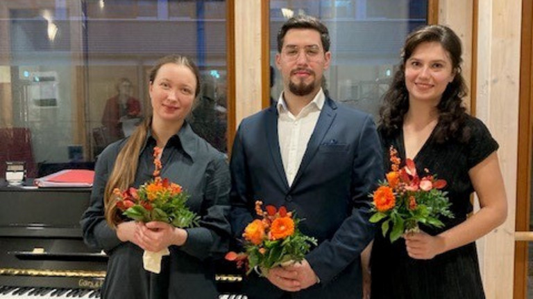 Daria Podushko, Laurence Kalaidjian, und Yekaterina Badeso stehen mit Blumen vorm Klavier, Live-Musik im Hospiz, Konzert für Hospiz-Gäste, Diakonie Hospiz Norderstedt