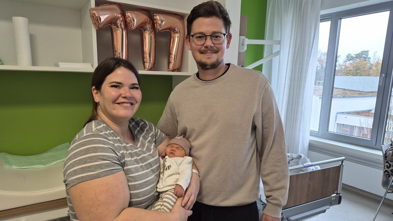 Hebamme mit Mutter, die das Baby im Arm hält und Vater in der Immanuel Klinik Rüdersdorf Hebamme mit Mutter, die das Baby im Arm hält und Vater in der Immanuel Klinik Rüdersdorf