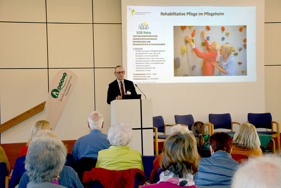 Geschäftsführer Ralf Zastrau stellt am Rednerpult neben einer Leinwand das Albertinen Haus vor dem Publikum in den Stuhlreihen vor Geschäftsführer Ralf Zastrau stellt am Rednerpult neben einer Leinwand das Albertinen Haus vor dem Publikum in den Stuhlreihen vor