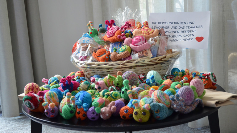 Gehäkelte Neskenschnecken in einem Korb auf einem Tisch