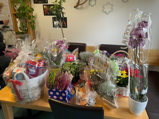 Ein Tisch mit mehreren Geschenkkörben und Präsenten zum 25-jährigen Jubiläum des Immanuel Suchthilfeverbunds Guben mit besonderen Wohnformen für abhängigkeitskranke Menschen in Thüringen Ein Tisch mit mehreren Geschenkkörben und Präsenten zum 25-jährigen Jubiläum des Immanuel Suchthilfeverbunds Guben mit besonderen Wohnformen für abhängigkeitskranke Menschen in Thüringen