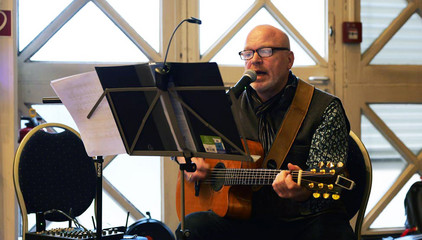 Rainer Bothe an der Gitarre vor einem Notenständer bei der Weihnachtsfeier 2025 von Amalie Sieveking Krankenhaus, Residenz am Wiesenkamp, Feierabendhaus Volksdorf und Albertinen Kindertagesstätte Volksdorf auf dem Gesundheitscampus Volksdorf in Hamburg