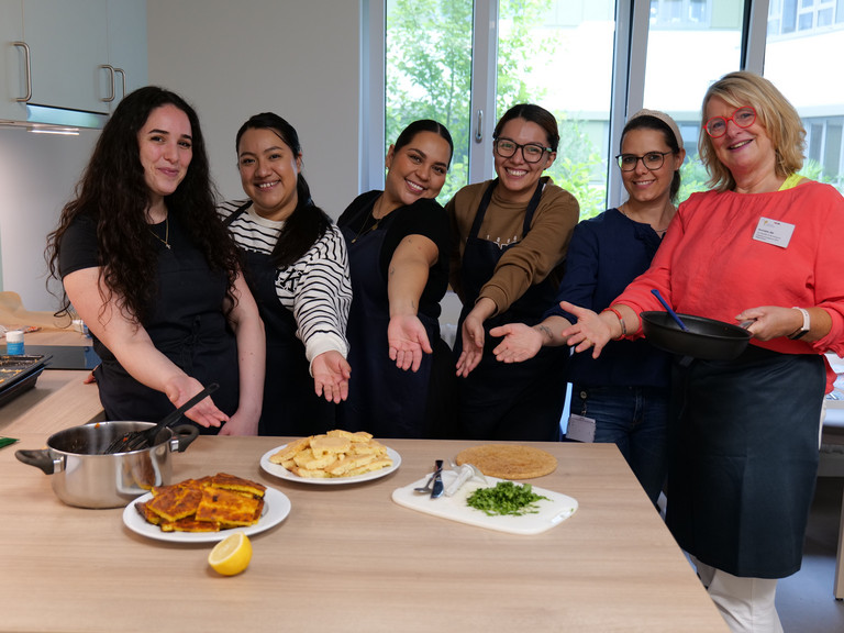 Gruppenfoto ausländische Pflegekräfte kochen und backen zusammen
