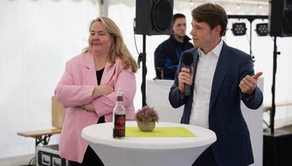 Konzerngeschäftsführer Dr. Thorsten Minuth spricht an einem Tisch neben Andrea Wichmann mit einem Mikrofon zu den Anwesenden im Festzelt bei der Jubiläumsfeier 20 Jahre Albertinen Services Hamburg ASH in Rellingen. Konzerngeschäftsführer Dr. Thorsten Minuth spricht an einem Tisch neben Andrea Wichmann mit einem Mikrofon zu den Anwesenden im Festzelt bei der Jubiläumsfeier 20 Jahre Albertinen Services Hamburg ASH in Rellingen.