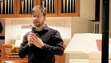 Kantor Matthias Berges vom Jugendchor der Kantorei Poppenbüttel begrüßt die Gäste beim Konzert in der St. Michaelskapelle auf dem Gesundheitscampus Volksdorf am Evangelischen Amalie Sieveking Krankenhaus in Hamburg.