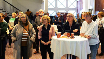 Mitarbeitende stehen im Amalie-Forum teilweise um Tische und blicken Richtung Rednerpult bei der Begrüßung zur Weihnachtsfeier 2025 von Amalie Sieveking Krankenhaus, Residenz am Wiesenkamp, Feierabendhaus Volksdorf und Albertinen Kindertagesstätte Volksdorf auf dem Gesundheitscampus Volksdorf in Hamburg