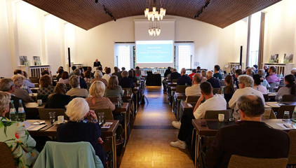 Blick in den Vortragssaal mit Sitzreihen, Tischen und Bühne beim Einführungssymposium „Die Zukunft ist alt!“ von Priv.-Doz. Dr. Gödel, Chefarzt der Klinik für Geriatrie im Albertinen Zentrum für Altersmedizin im Albertinen Krankenhaus in Hamburg.